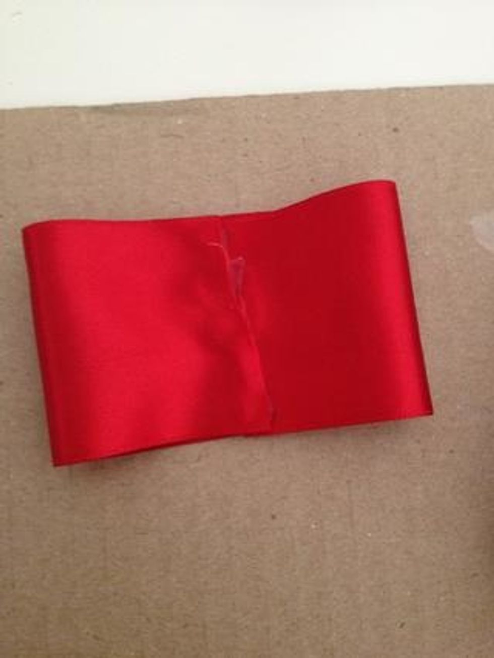 Next, fold the other side of the ribbon and place it on top of the other folded ribbon side.