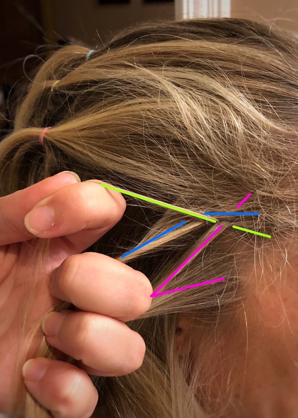 Next, gather a small section of hair and add it to the pink (right) strand.