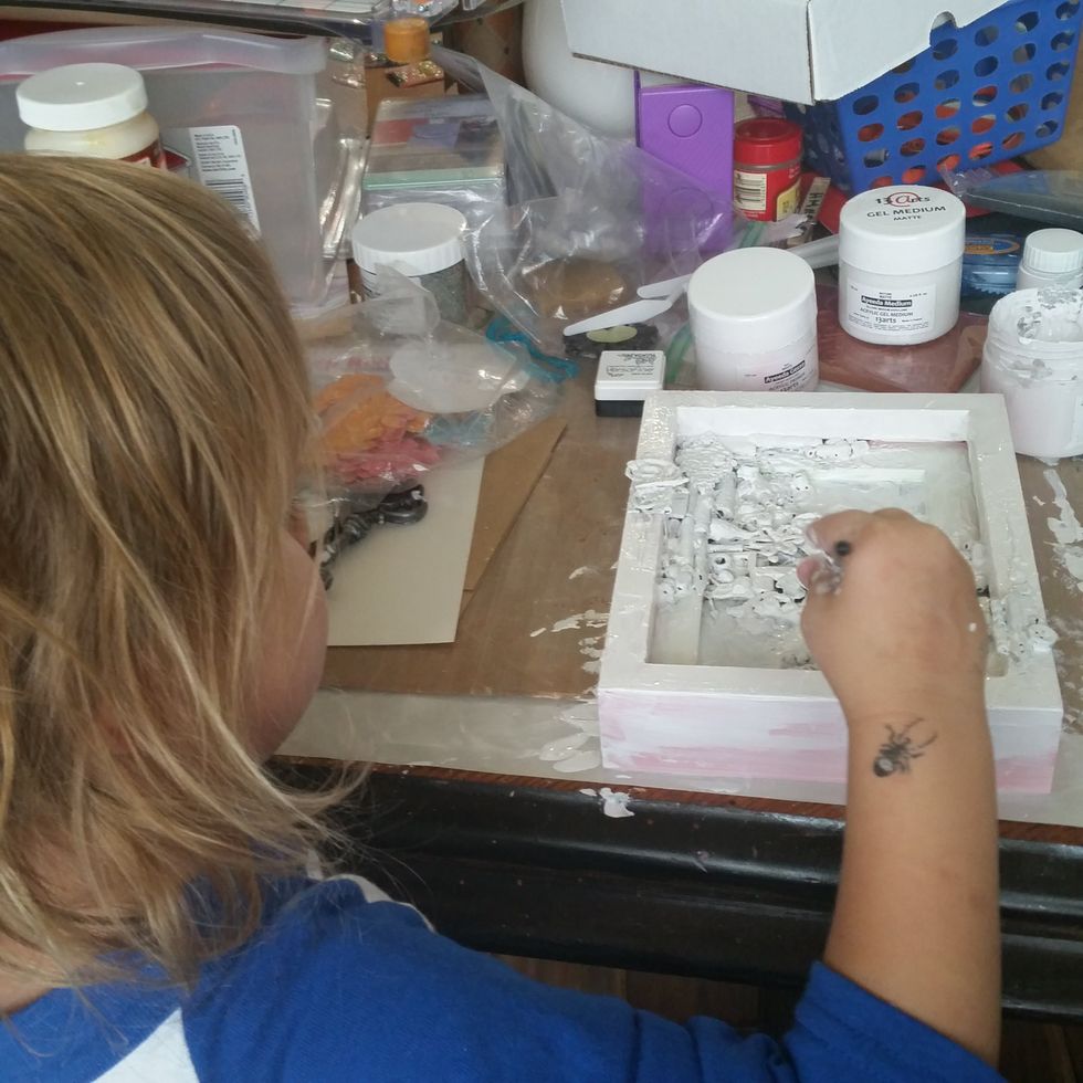 Next gesso everything, from the frame and all the little bits inside. It took me 2 coats to white wash everything. Here is my daughter helping me paint the gesso.