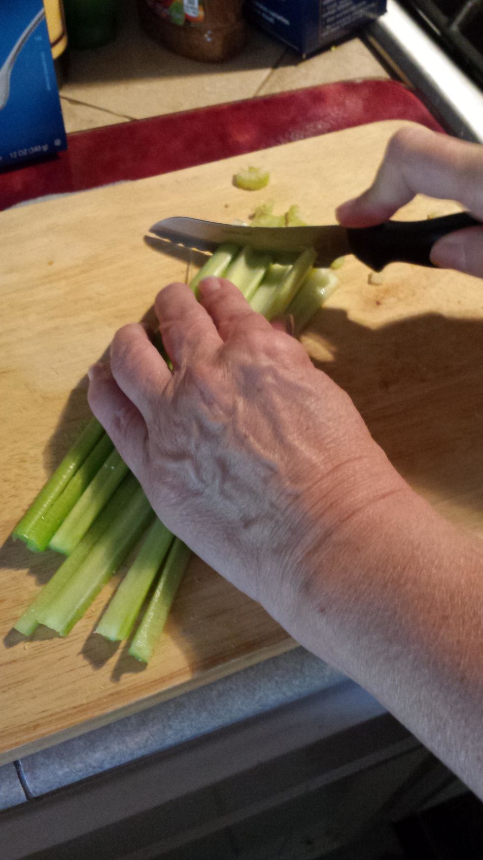 Next, get 2 stocks of celery, and cut them in half, half again, and then into small pieces and add them to the bowl.