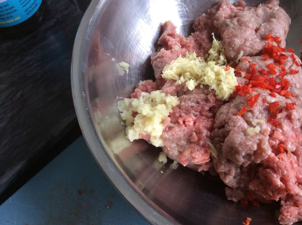 Next get 500 grams of pork mince. Also add the capsicum, chilli, garlic and ginger. Add 1 tablespoon of fish sauce, 1 tablespoon of peanut oil, and 1 tablespoon of sweet chilli sauce.