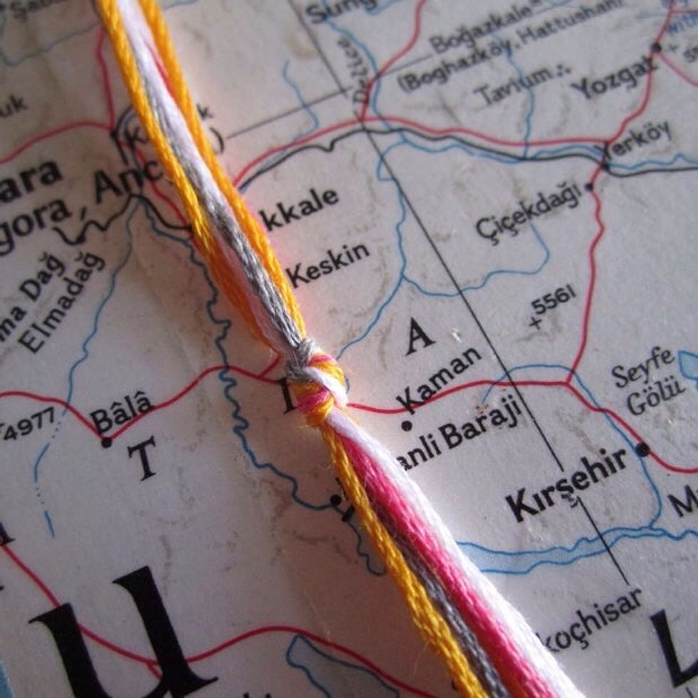 Next, get however many colors of thread that you want. That's how many colors will be on you bracelet. Then, put them all together and tie a knot at the top of the thread. Don't make them too long.