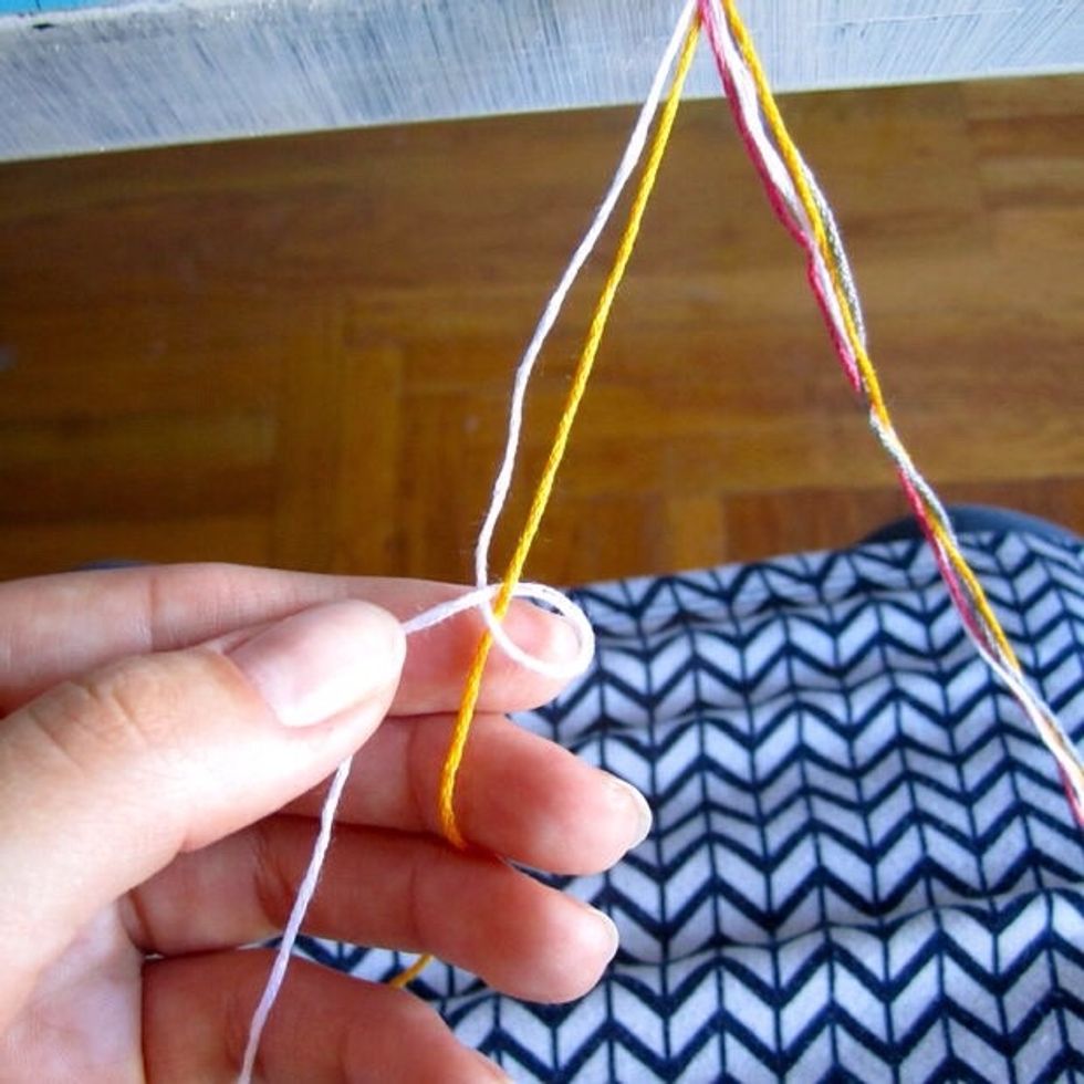Next, get the thread that is the farthest to the left and fold it over the one next to it so that it looks like you're making a "4". http://www.instructables.com/