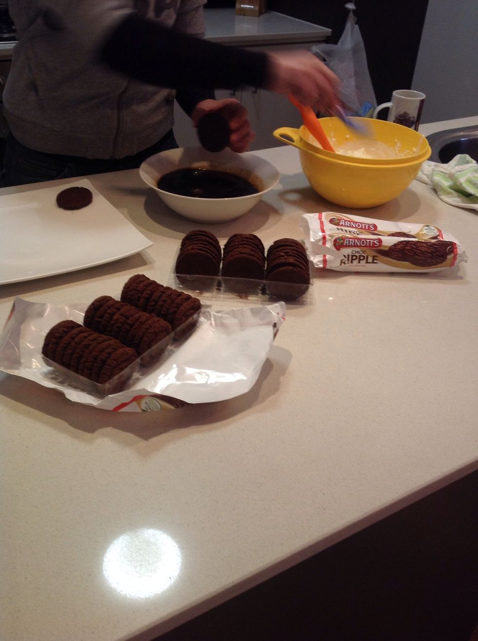 Next get your biscuit and dip one half into the coffee then with a butter knife spread cream on the side you dipped the coffee in