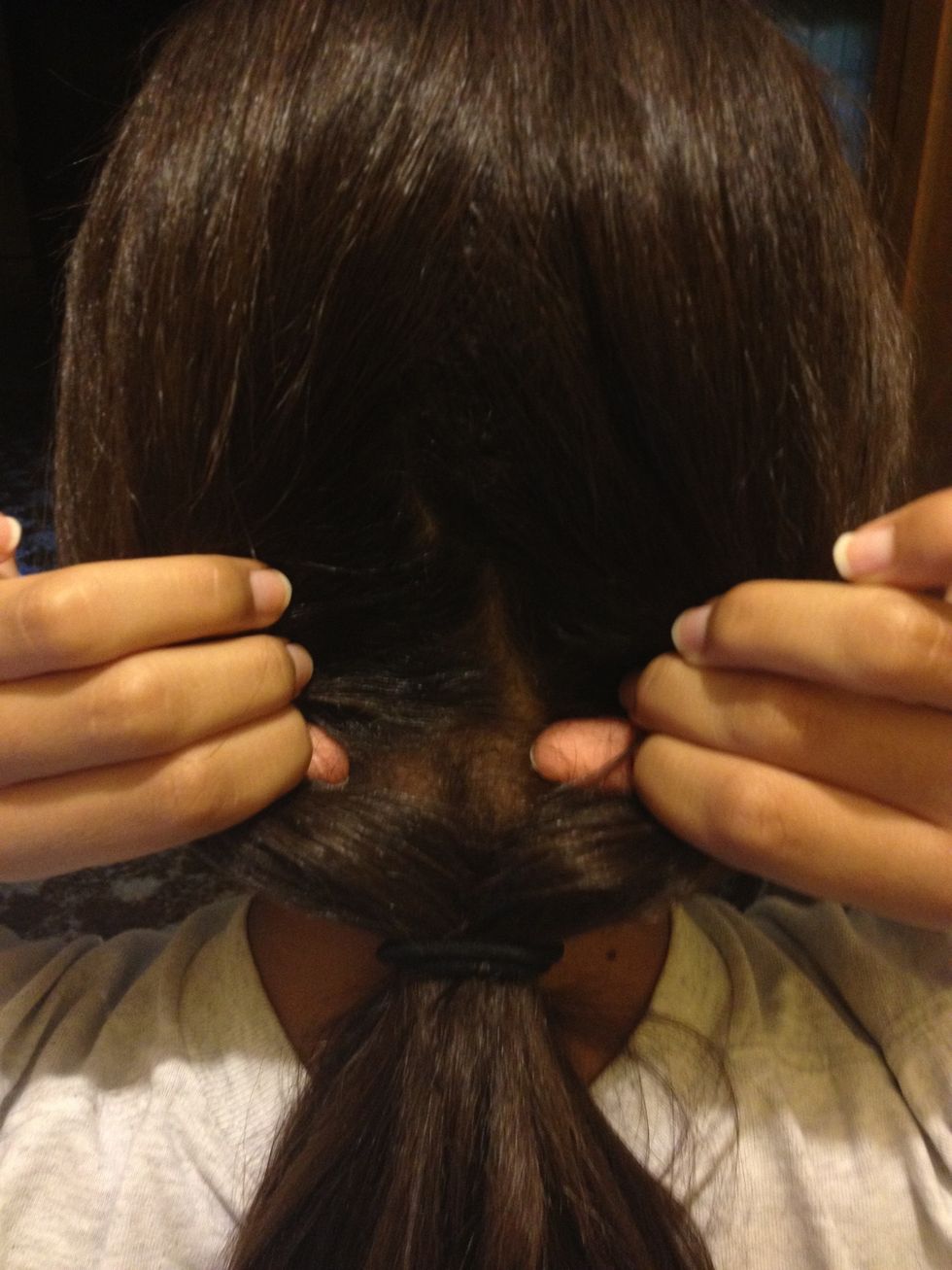 Next, go a little bit above where the hair tie is and open up your hair so that there is a gap like this.