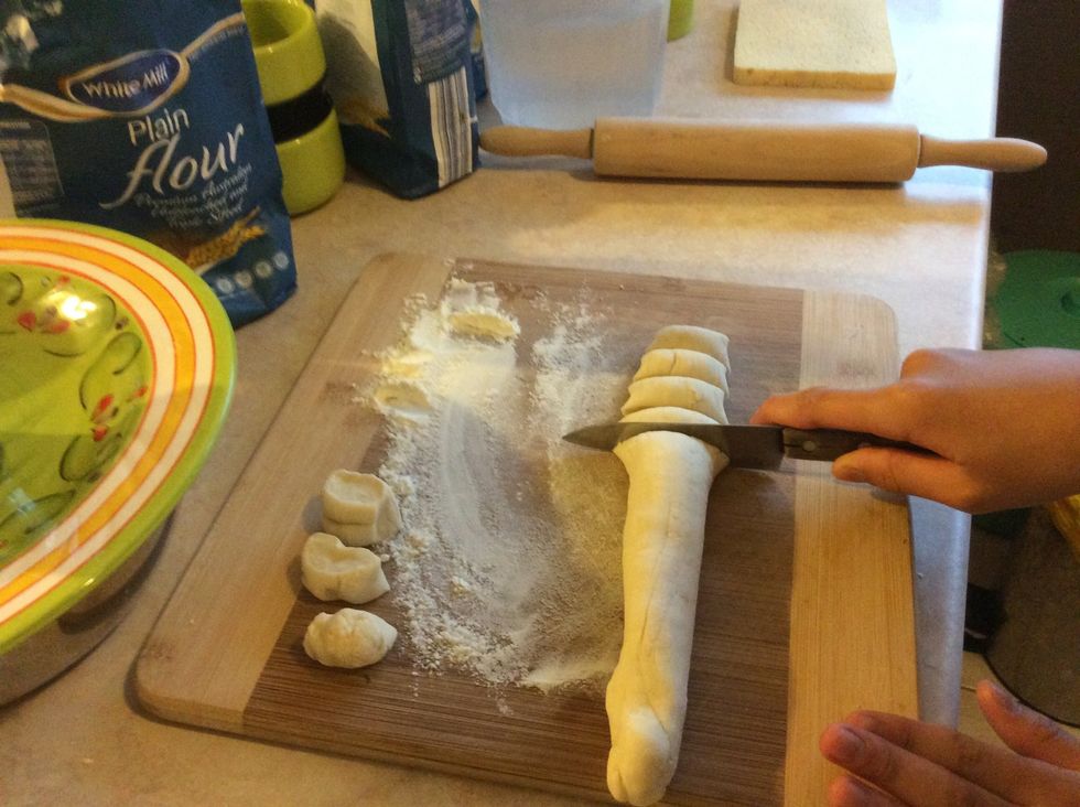 Next, grab some flour and roll it into a long strip. Next thing you need to do is chop up the strip. The pieces don't have to be very big.