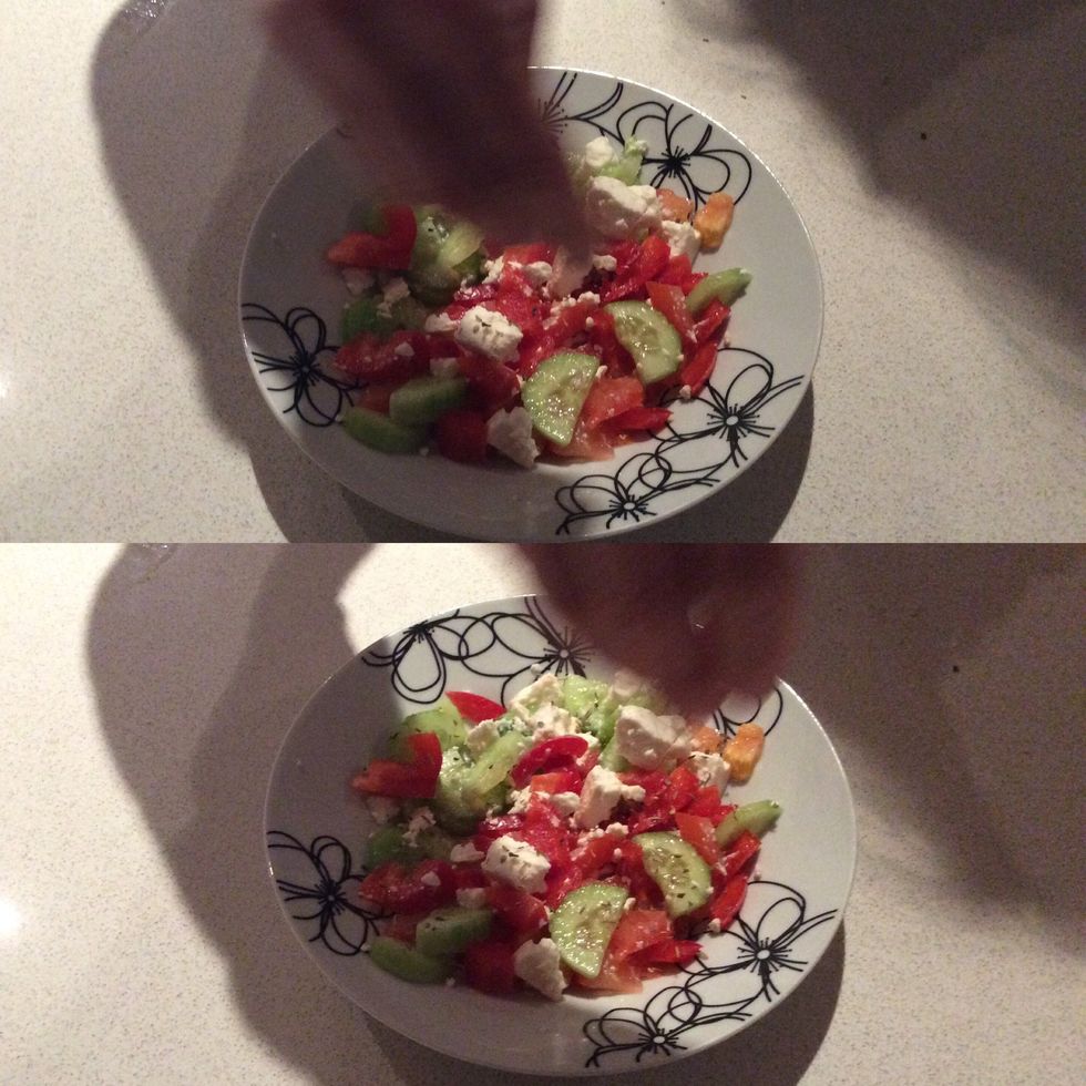 Next grab the oregano or the herbs, and clearly sprinkle it over the salad.