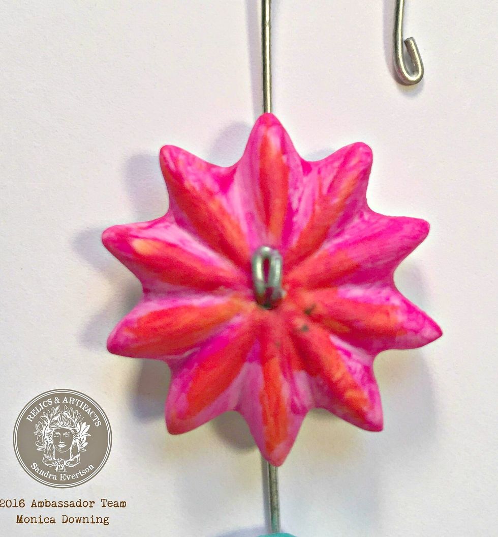 Next I painted the flower a bright pink, for this I used a brush. I also painted the area around where the hook attaches to the pendant