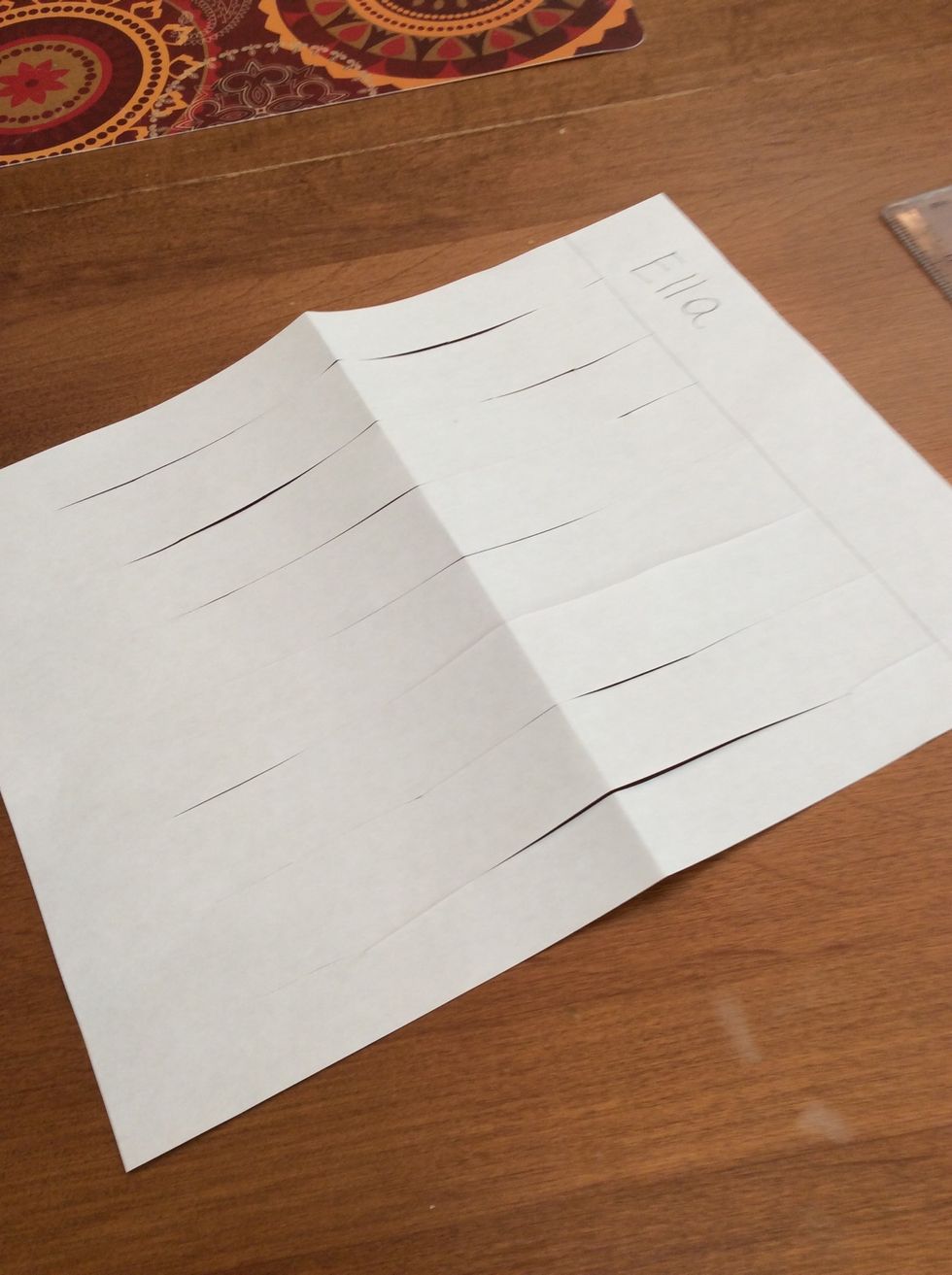 Next I unfold my paper. This is my LOOM. The lines that I cut are the WARP.