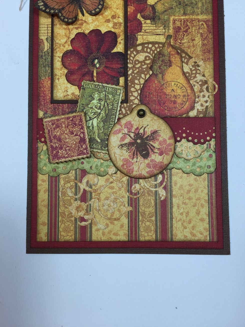 Next is the round tag you stamped earlier. Pop up with foam squares and add a small embellishment over the hole. I used an "Artisan Stud" from Close To My Heart.