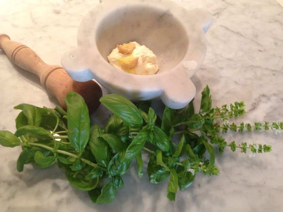 Next, make the spread! In a food processor or mortar and pestle, combine \u00bd cup mayonnaise, a handful of fresh basil leaves, a clove of garlic, and a dash of olive oil.