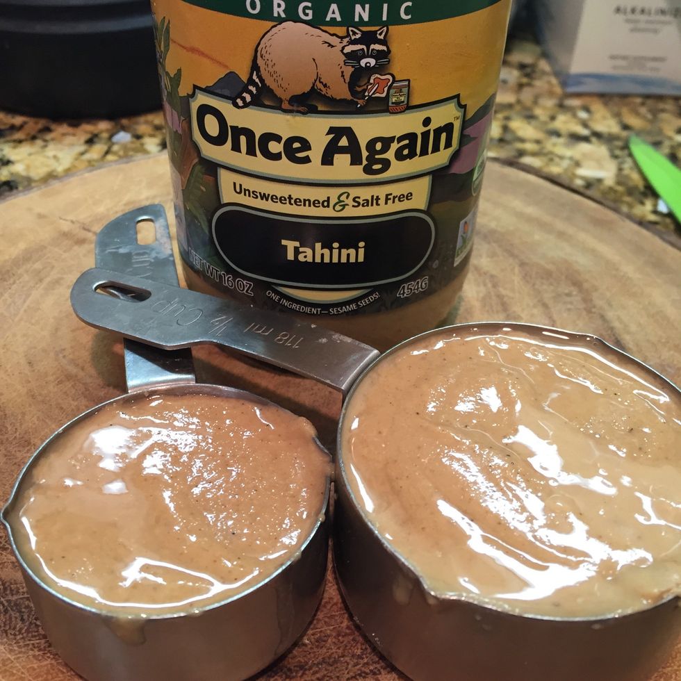 Next, measure 3/4 cup tahini and add it to the blender.