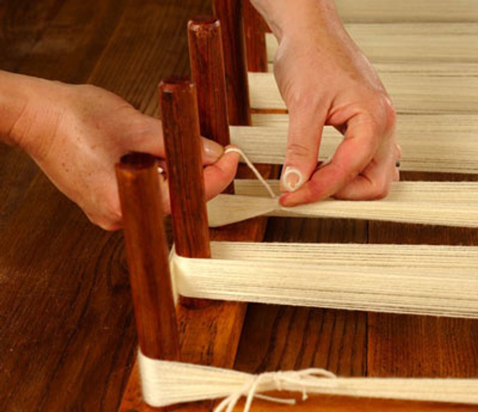 Next must you tie all the yarn strands to the peg.