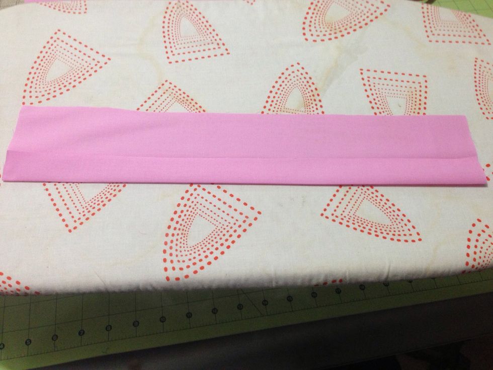 Next open it & fold one edge to the crease. press just the new fold.  Repeat with other side.  When you are done you should the raw edges lined up with the original crease.