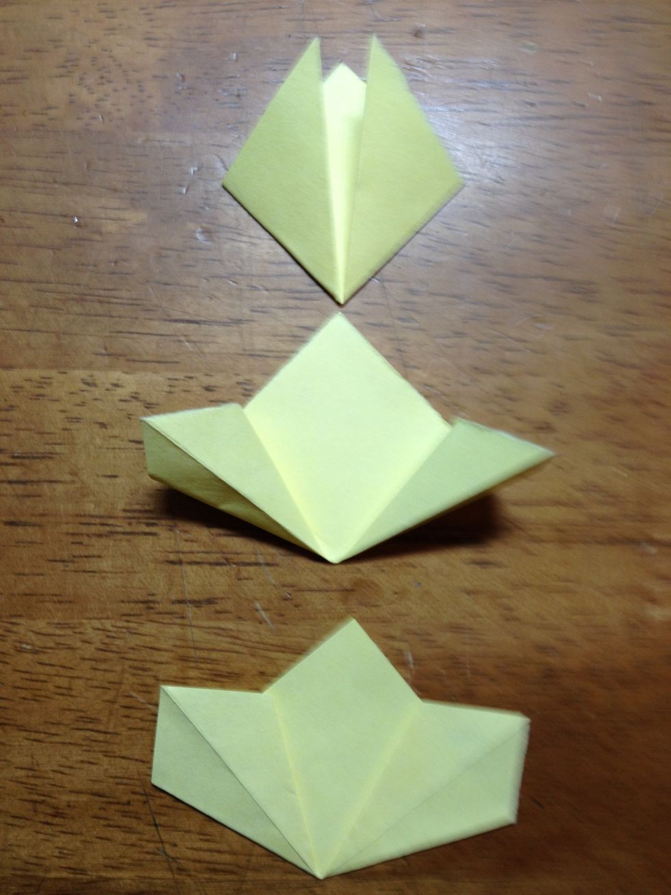 Next, open up both flaps, so that they look like the second model. Once they are open, push the flaps down so that they are flat and that the corners of the flaps line up with the back piece.