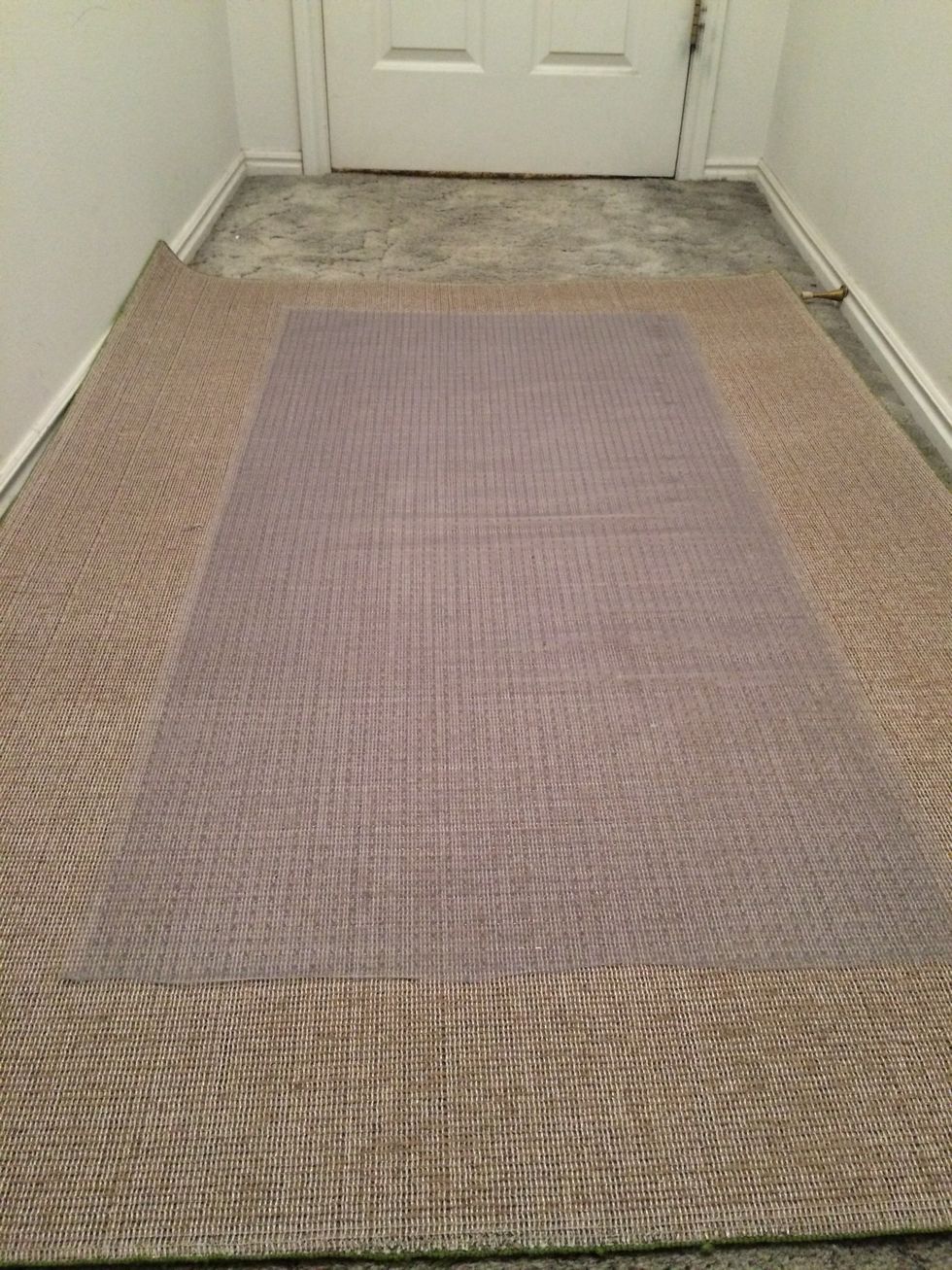 Next, place the vinyl runner upside down and center it on the area rug. You can purchase runners by the yard at box stores.