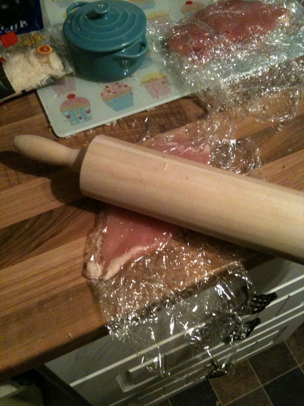 Next place your chicken breasts individually between a piece of cling film (or seran wrap or whatever u call it) and bash it gently with the rolling pin until it is all an equal, thin size- not 2 thin
