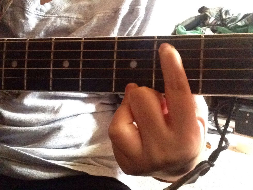 Next, place your pointer finger on the A string in the second fret.