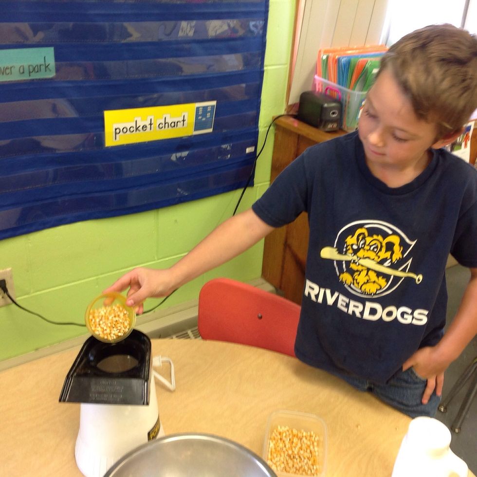 Next, pour half of  a cup of seeds into a the popper.
