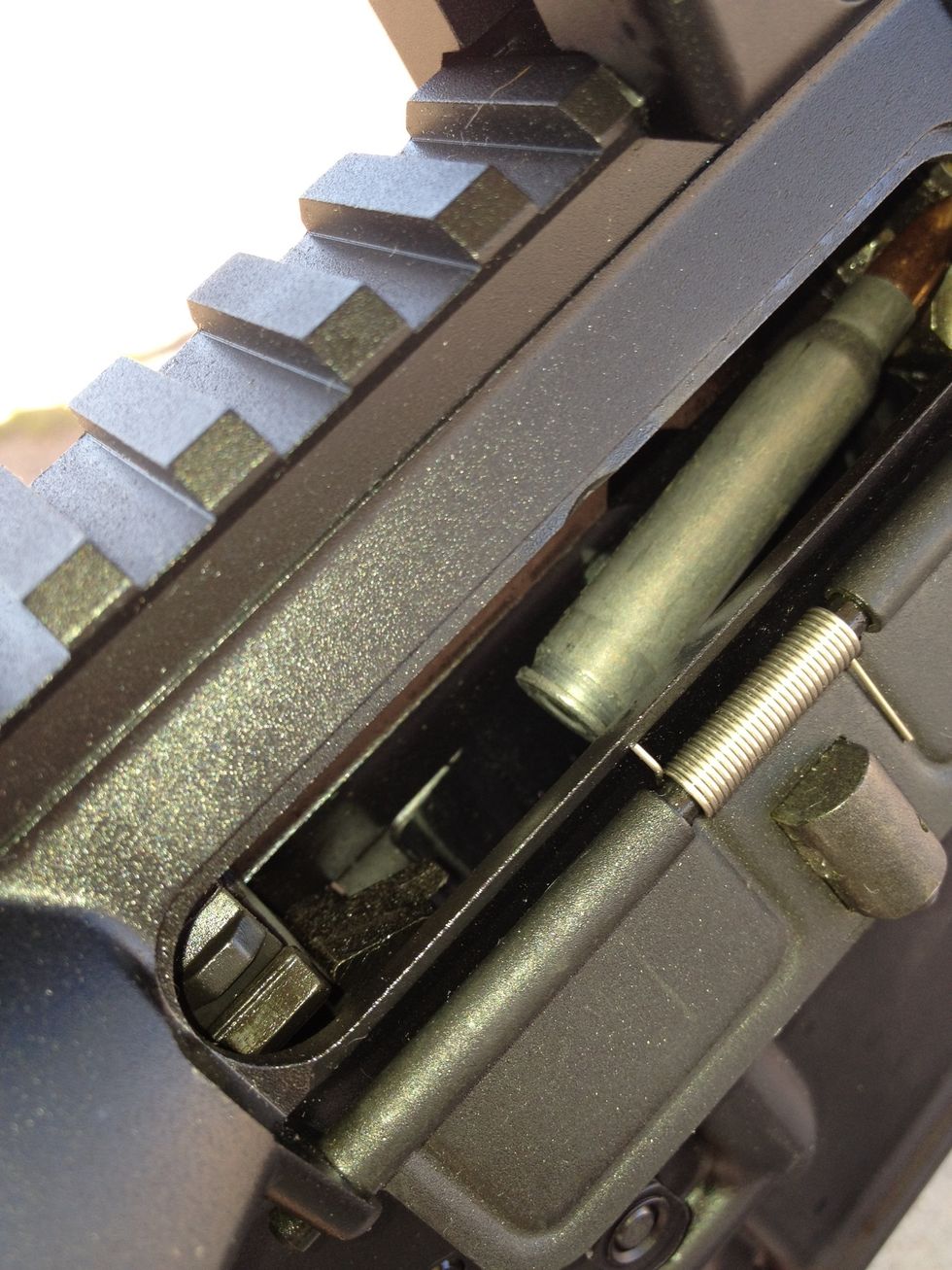 Next, pull back and lock the bolt so its not pressing the live round against the jammed casing.