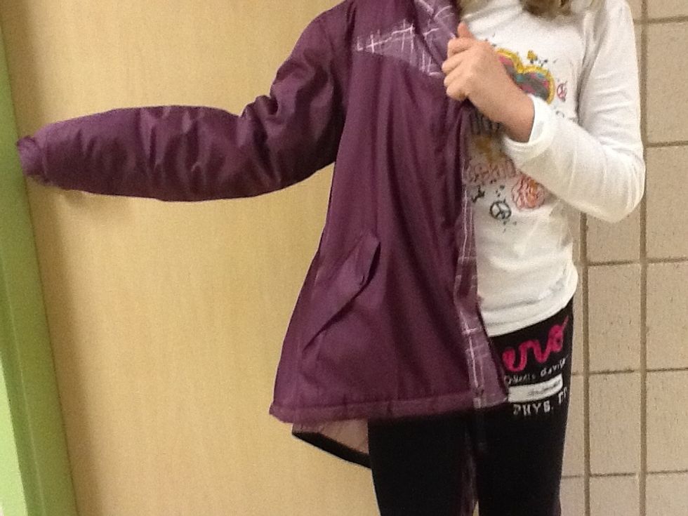 Next pull your coat towards you and push your arm through the hole