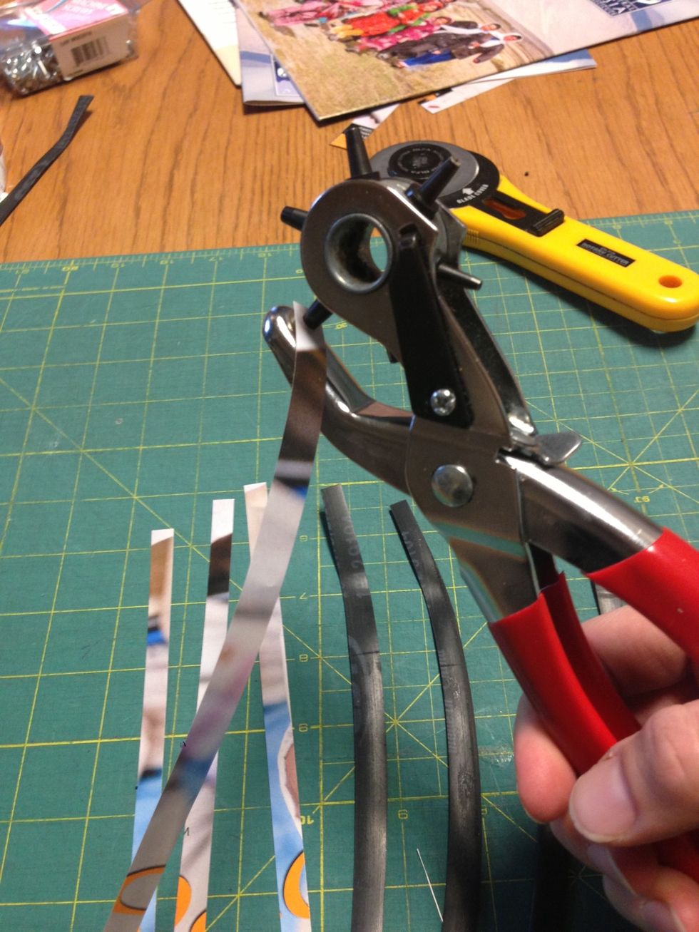 Next punch holes in the strips of material. Each strip will have 3 holes, one in the center and one at each end.