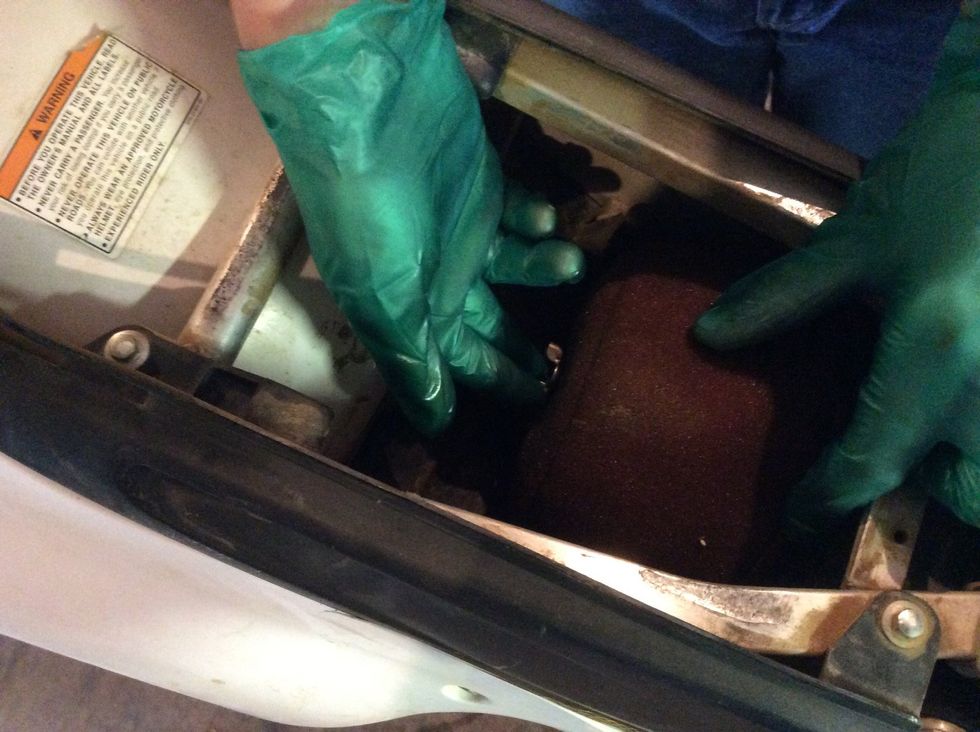 Next, put on the rubber gloves, andremove the air filter by taking out the wing nut holding it in. Make sure to cover the hole to the engine with a clean cloth or rag to keep dust out.