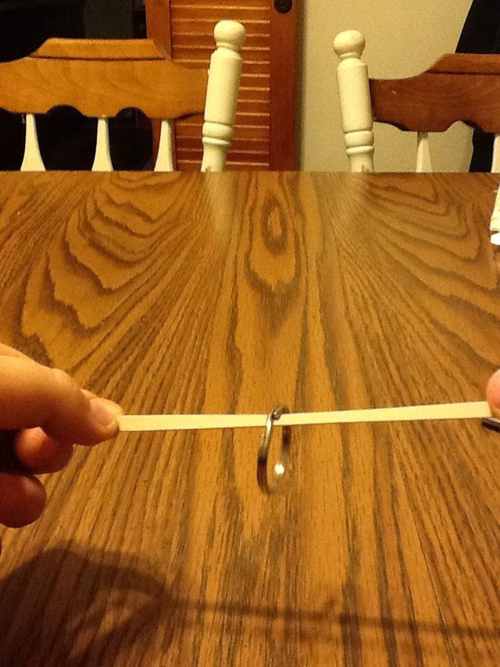 Next put the ring on the rubber band