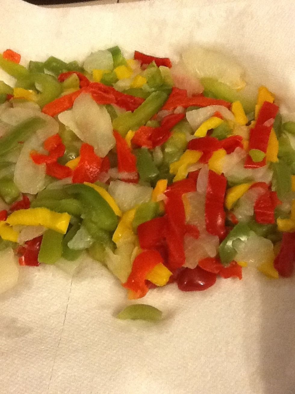 Next, remove the peppers from the bag and pat them with a paper towel to remove as much moister as you can. Then add them to the saut\u00e9 pan with the onions and garlic. Cook for10 minutes.