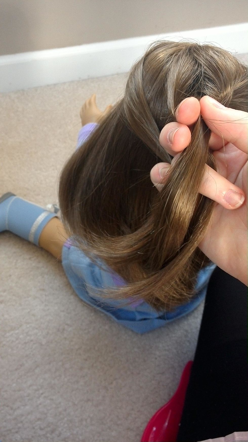 Next, retrieve a section of hair from the left side of the head and pull it back, still holding all of the other strands in place between your fingers.