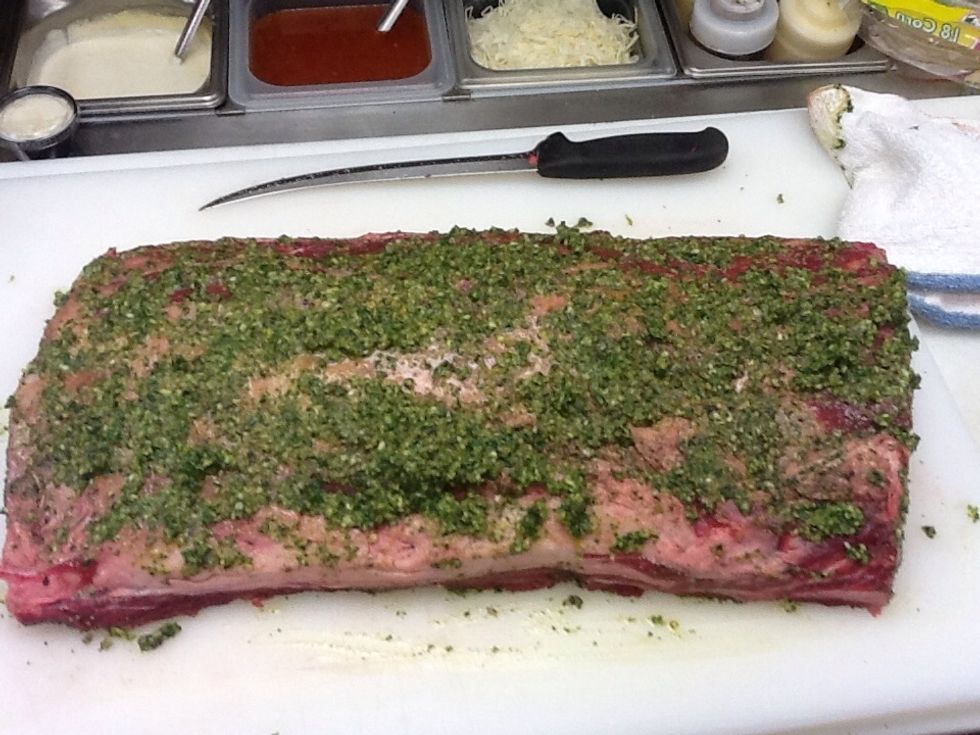 Next, rub with a paste made of fresh garlic, fresh thyme, fresh Italian parsley, fresh oregano, and olive oil.