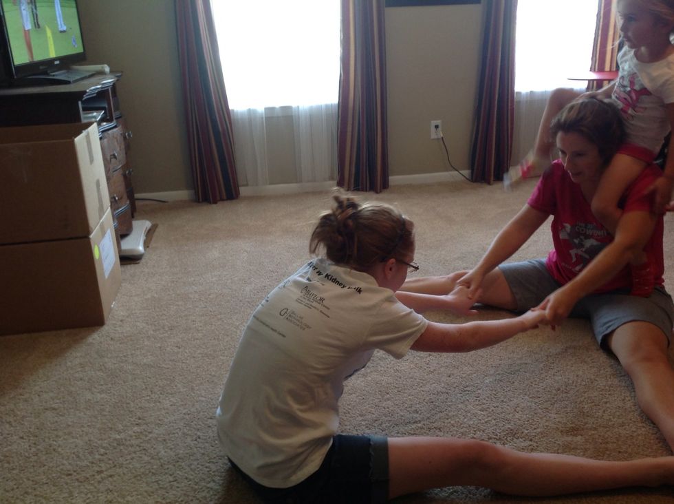 Next sit on the floor in a V. Use your big kid and you can both get a great leg stretch. If one of you is flexible (kid) and the other isn't (me).. That's okay, just stretch as far as you can.