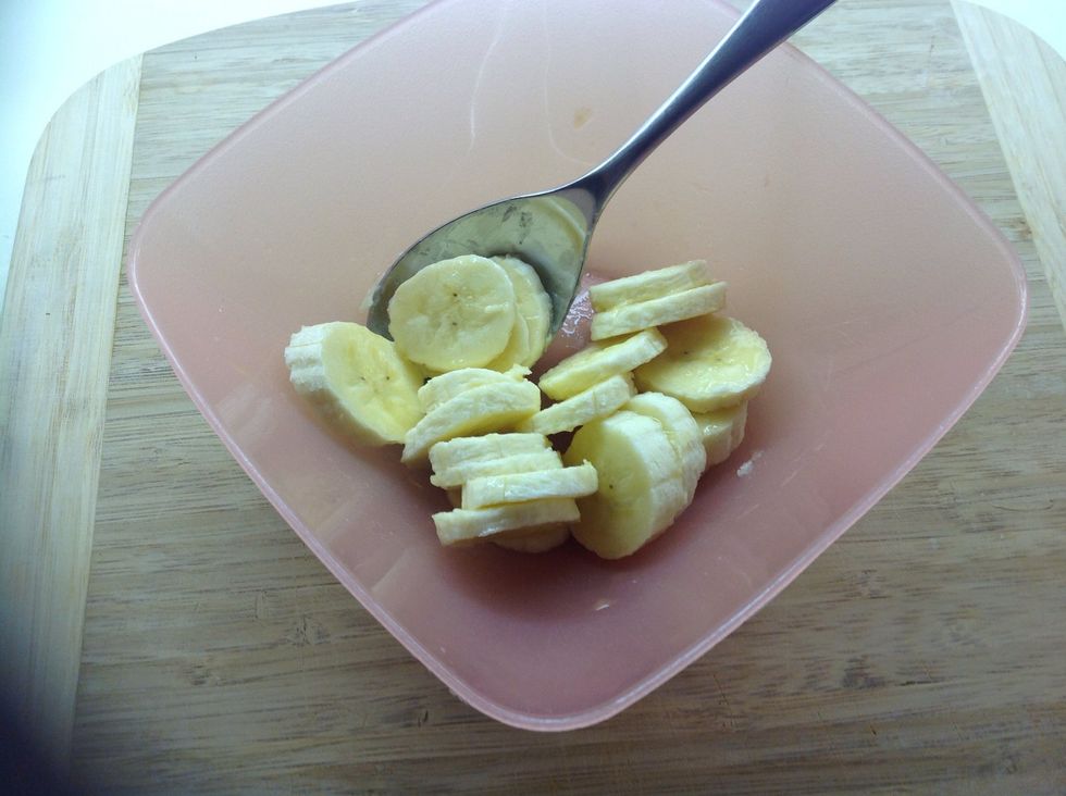 Next, slice the banana into another small bowl and splash a little orange juice on top. I used about 2 teaspoons here. Stir to coat the banana.