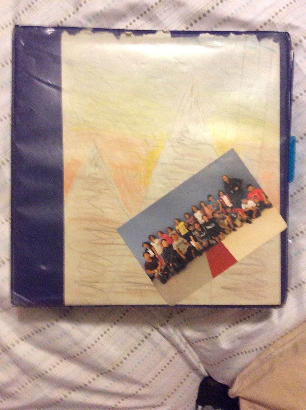 Next slip in a class photo or a photo of you . It might need to be small depending on what size your binder is.    PS: This photo is from this year. You can change this photo every year.