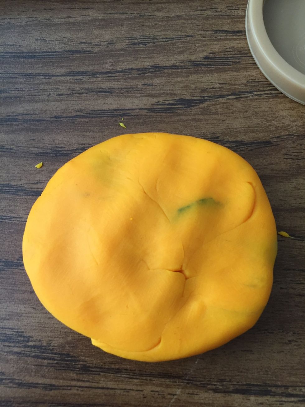 Next squish the orange play doh ball flat into a pancake.