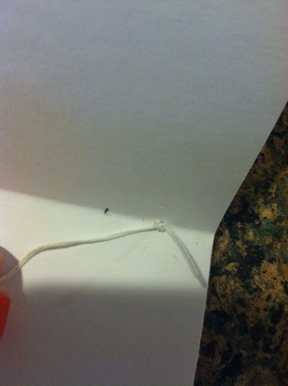 Next station, push needle through paper pull tight, the cardboard outside to the inside, pull tight , needle back through the same station, pull tight to attach the cover to the first signature.