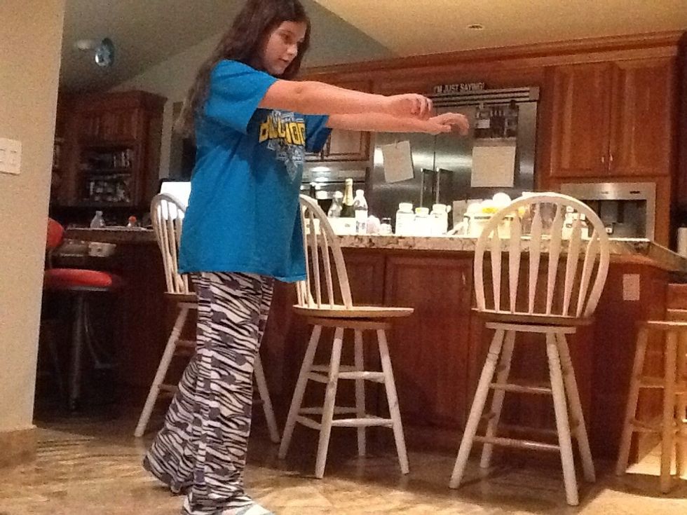 Next, swing your arms forward, so they are parallel to each other.