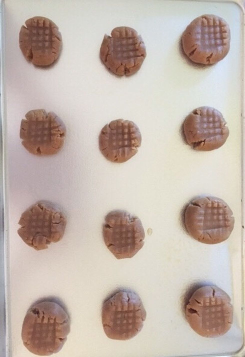 Next take a fork and create a criss-crossed pattern on the tops of the cookies.