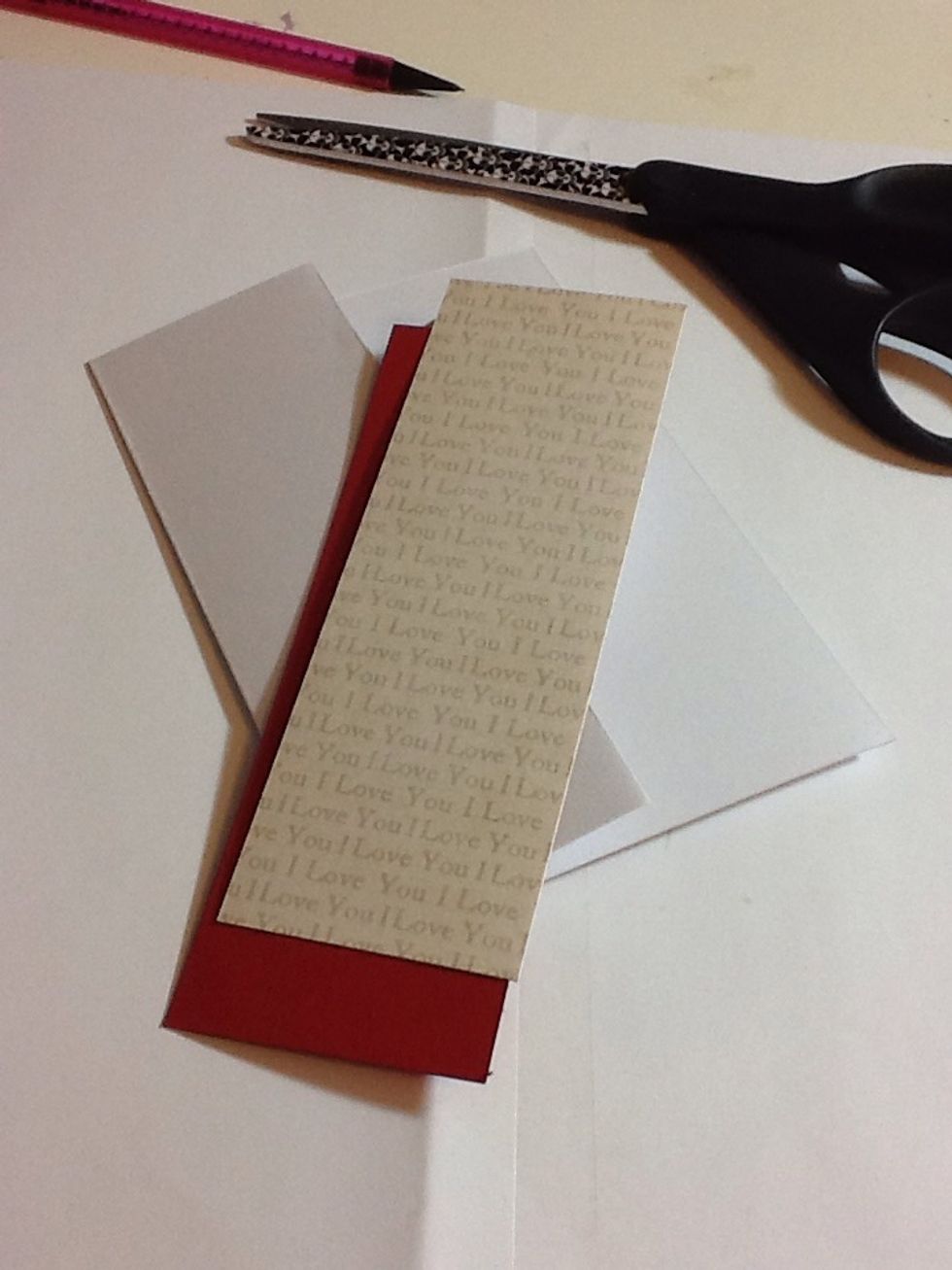 Next take a piece of card and one your patterned papers. Cut two rectangles, the card to the size of the left hand side of the base card and the paper slightly smaller