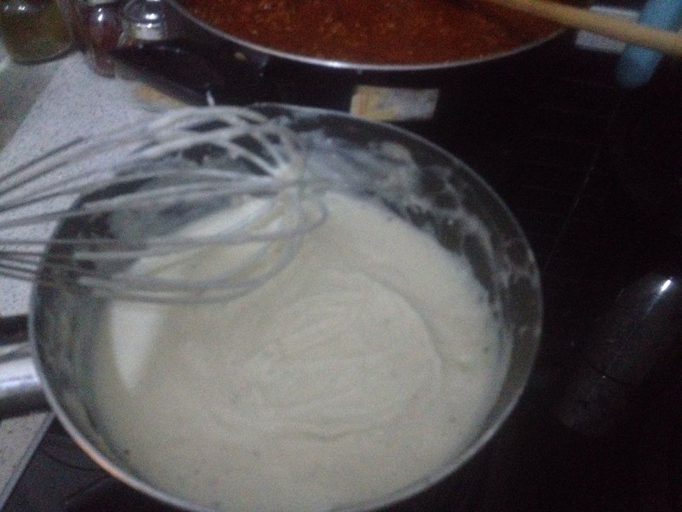 Next take back to a low heat and slowly add 1.5 cups of milk whilst whisking the mix together. Lastly add 2 large spoons of cheese spread and a cup of grated cheddar.