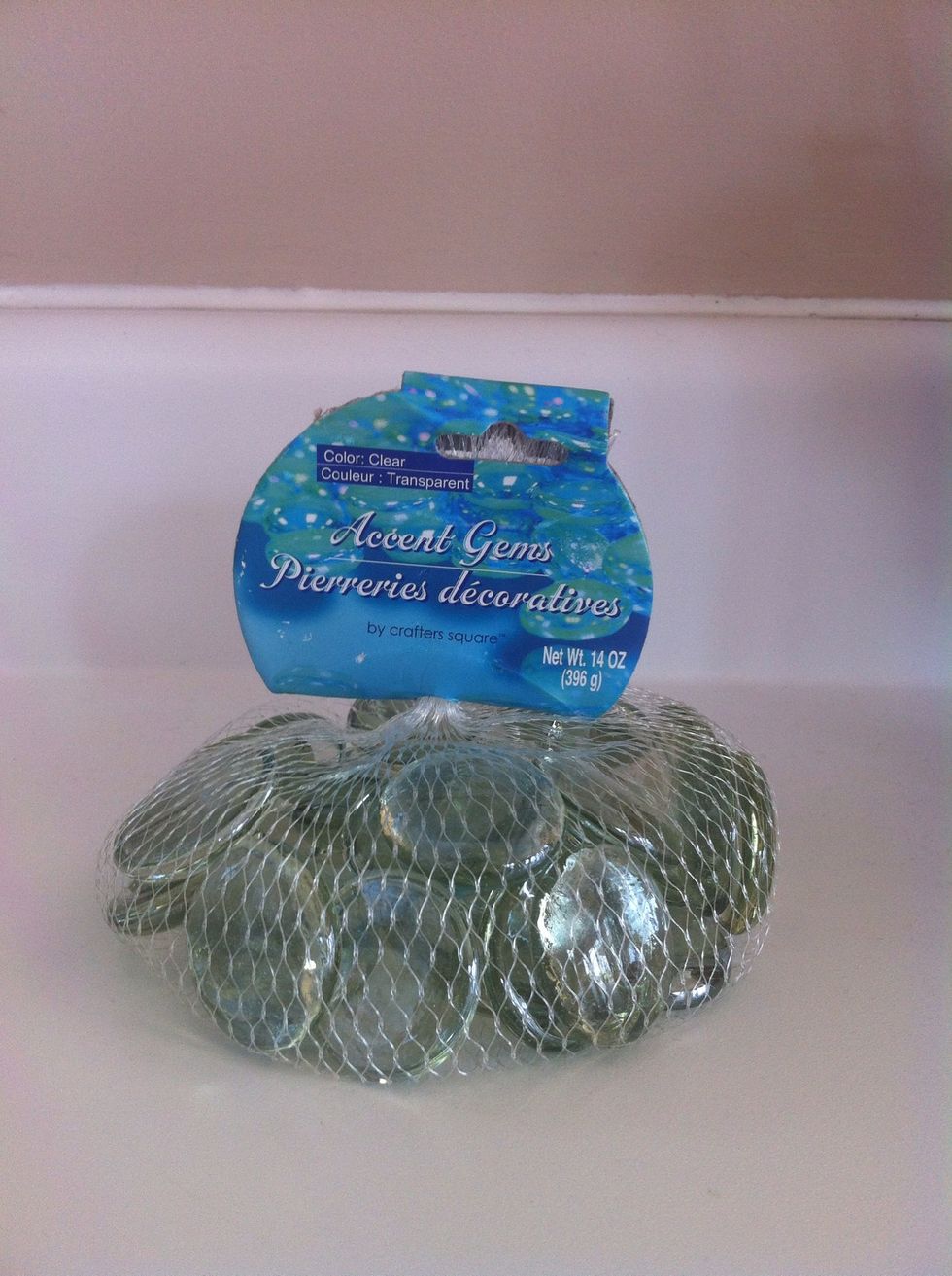 Next take whatever you want to fill your centerpiece with and fill it! (I got these glass pebbles from my local dollar store)