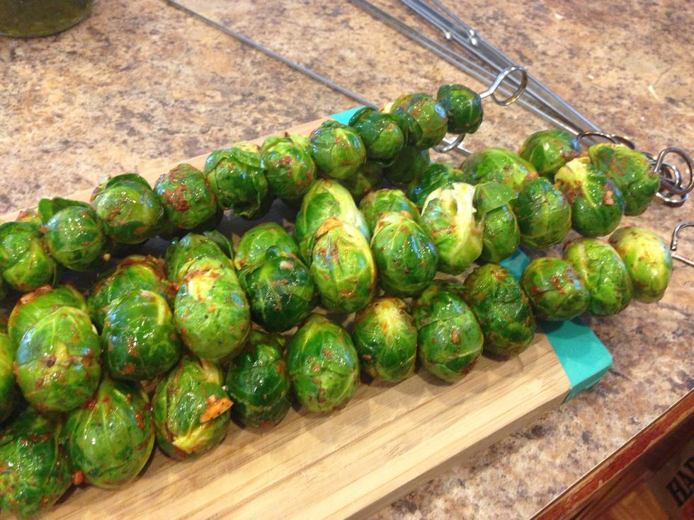 Next, thread the Brussels sprouts on the skewers. Try to put the same sized Brussels sprouts together so that they will cook evenly.