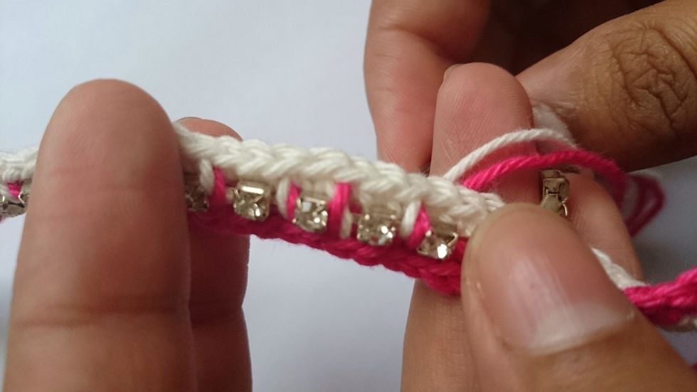 Next,thread yarns of both the colours through the yarn needle and attach the rhinestone.