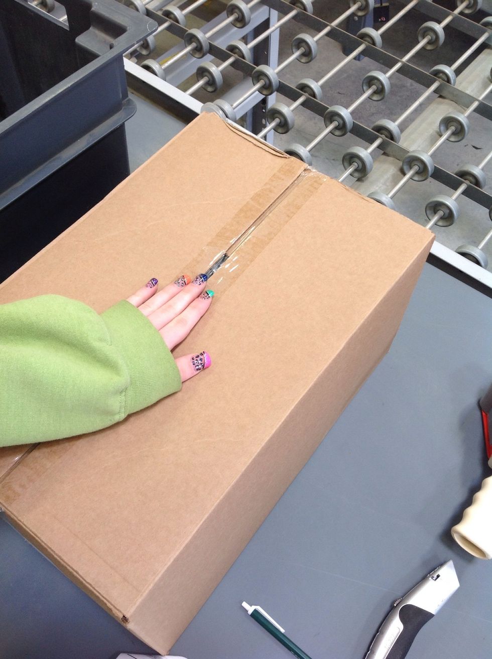 Next, turn in the large flaps of the box so that they meet in the center and are aligned.