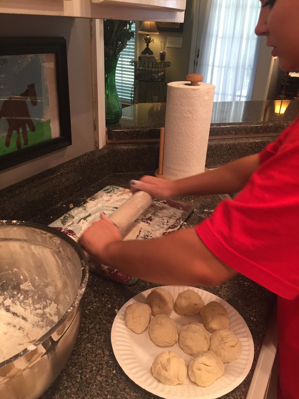 next, use a floured rolling pin and roll the balls of dough into thin, flat tortillas