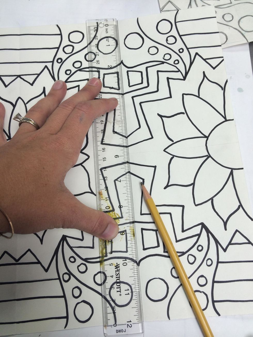 Next use a ruler and pencil to draw a line on the original folds in the paper. This will help us later when we add COLOR to our design.