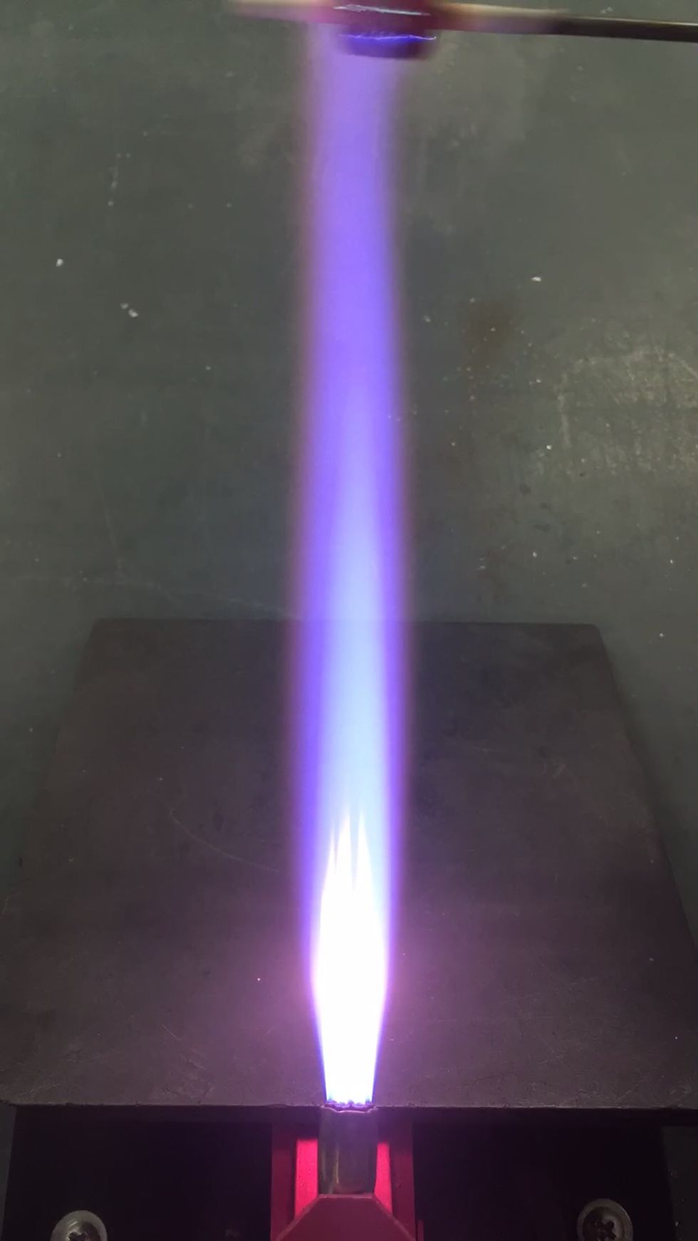 Next we are going to gently reduce the bead. Turn up your propane a bit until the yellow candles are an inch or two long, and pass the bead briefly through the furthest reaches of the flame.