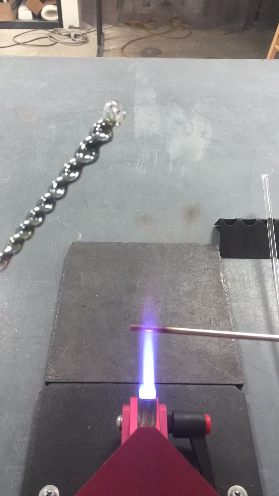 Next we are going to separate the icicle from the remaining punty. Heat up a bare mandrel until it has a slight glow.