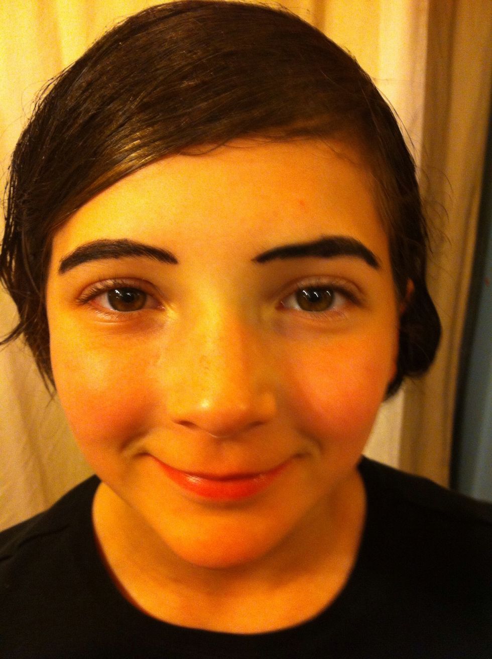 Next we drew over her brows with black liner to make them pop.