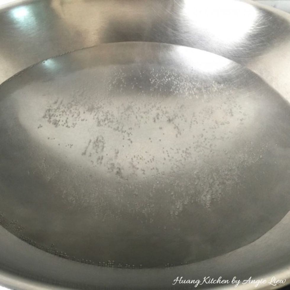 Next, we need to cook the glutinous rice balls. First bring a wok or saucepan of water to a rolling boil.